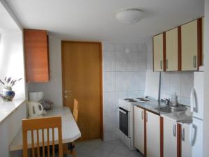 a small kitchen with a sink and a stove at Studio apartman Kornelija in Lumbarda