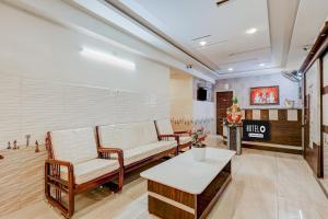 a waiting room with chairs and a table at Super Hotel O Eluru Railway Station Formerly Sree Nitya Residency in Elūru