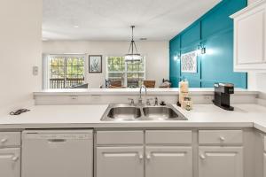 a kitchen with a sink and blue cabinets at Charming 3-Bedroom Cherry Grove Condo in Myrtle Beach