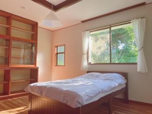 un dormitorio con una cama y una ventana en HOTEL DanDan, en Shuzenji 7 fotos más