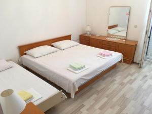 a small bedroom with a bed and a mirror at Apartments Katnić in Hvar