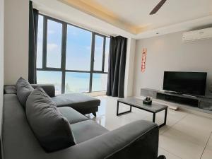 a living room with a couch and a flat screen tv at Jazz Service Suites Penang in George Town