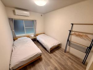 Postel nebo postele na pokoji v ubytování Satsuki Apartment Hotel - Koguchi Area