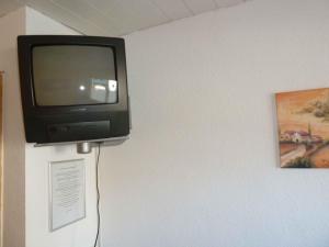 einen Fernseher an einer Wand neben einem Gemälde in der Unterkunft Privatzimmer Reiner Baumeister in Lindau