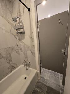 une salle de bain avec une douche, une baignoire et un lavabo dans l'établissement Grand House, à Chicago 11 autres photos