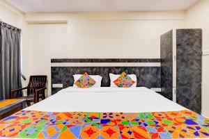 1 dormitorio con 1 cama grande y colcha colorida en FabHotel Sri Lakshmi Sea Grand, en Jāmb