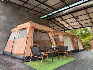 a tent with chairs and a table in front of it at Camping House Kohkood in Ban Khlong Mat