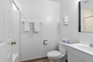 Un baño blanco con inodoro y lavabo. en 2 Brand-New Combined Family Studio Apartments, en Lake City