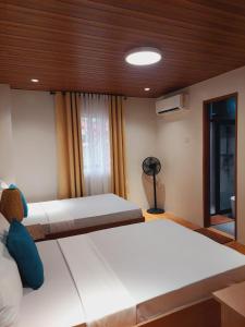 1 Schlafzimmer mit 2 Betten und einem Ventilator in der Unterkunft The Grove by Six Marys Resort in Bacolor