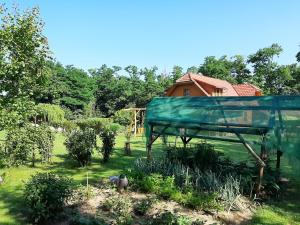 a bird house in a garden with a house in the background at Ezerjó Ökofogadó in Őriszentpéter