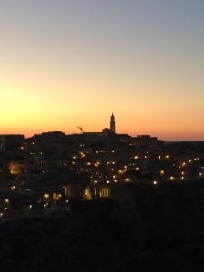 una città di notte con una torre dell'orologio su una collina di Landscape B&B a Matera