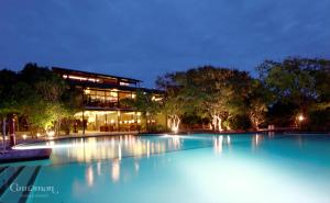 a swimming pool in front of a building at night at Cinnamon Wild Yala in Yala