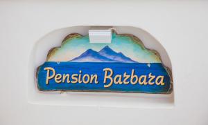 a sign that says pension barbara hanging on a wall at Pension Barbara in Katapola