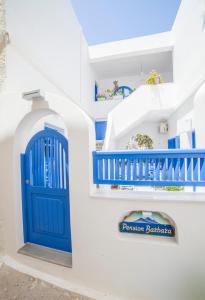 a blue door on the side of a white building at Pension Barbara in Katapola