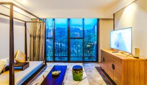 a living room with a large window and a television at Yangshuo Courtyard Hotel - An all-English team by the Li River in Yangshuo +15 photos