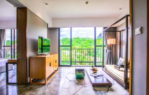 uma sala de estar com uma grande janela e uma televisão em Yangshuo Courtyard Hotel - An all-English team by the Li River em Yangshuo