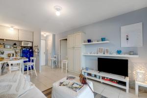 a living room with a couch and a tv at Cosy Apartement Gaia Villeneuve-Loubet - Happy Rentals in Les Beaumettes