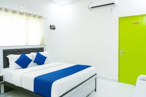 a bedroom with a bed with blue pillows and a green door at Comfort Stay - Near Airport in Lucknow +9 photos