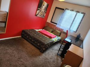 - une petite chambre avec un lit et un mur rouge dans l'établissement 69Room69, à Lyon