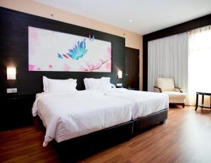 a bedroom with a large bed with a large painting on the wall at Vouk Hotel Suites, Penang in George Town