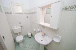 a white bathroom with a sink and a toilet at Pension Barbara in Katapola
