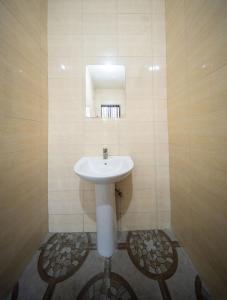 a bathroom with a white sink and a mirror at MASOMZ Lodge in Dar es Salaam +16 photos
