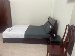 a small bedroom with a bed and a chair at Hottel ANH LONG in Buôn Ðũng