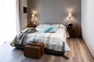 una camera da letto con un letto con cuscini blu e una valigia di Alla Meta a Mogliano Veneto