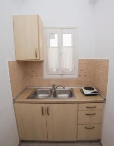 a small kitchen with a sink and a window at Pension Barbara in Katapola