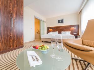 a hotel room with a bed and a table with a bowl of fruit at Hotel an der Oper in Chemnitz