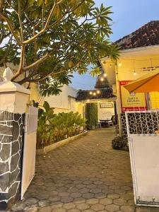 a walkway leading to a building with a tree at Pi Home by Perwira Hub in Yogyakarta
