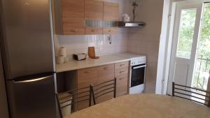 a small kitchen with a refrigerator and a table at Apartment Lelli in Split