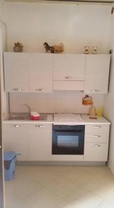 a kitchen with white cabinets and a black oven at Casa Vacanze Da Giusy in Matera