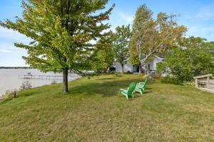 un paio di sedie verdi sedute su un prato accanto a un albero di Double Bed suite in Heart of Lake City a Lake City