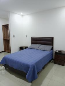 a bedroom with a bed with a blue blanket on it at Dulce hogar in Santa Cruz de la Sierra