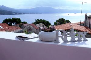 a sign that reads read sitting on a table with a vase with a plant at Holiday home Gabriela in Korčula