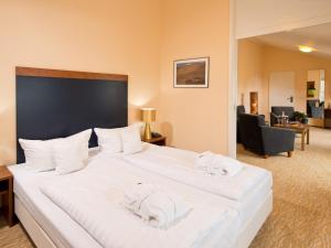 a bedroom with a large white bed with white towels on it at BHB - Boutique Hotel Buchholz in Buchholz in der Nordheide