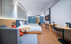 成都市にあるQingju Hotel, Chunxi Road, Taikoo Li, Chengduのベッドとテーブルのあるホテルの部屋