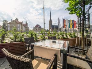 a table and chairs on a balcony with a view of the city at Hotel an der Oper in Chemnitz