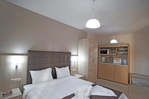 a bedroom with a large bed and a kitchen at Kochili Seashell Apartments in Siviri