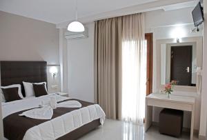 a bedroom with a large bed and a window at Kochili Seashell Apartments in Siviri
