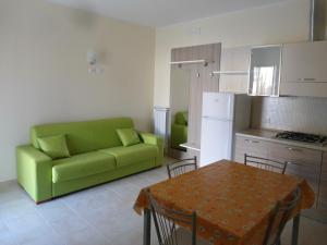 sala de estar con sofá verde y mesa en Appartamento Bilocale a 200 m dalla spiaggia en Vieste