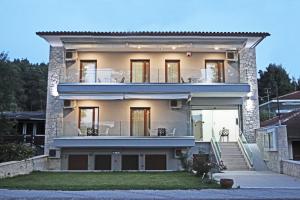 a large white house with a porch at Kochili Seashell Apartments in Siviri
