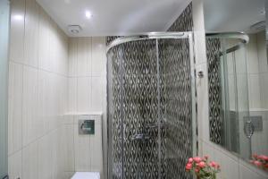 a shower with a glass door in a bathroom at Kochili Seashell Apartments in Siviri