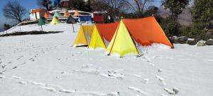 a row of colored tents in the snow at Nag Tibba Trek - Three Sixty Views in Miānī