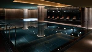 a swimming pool with chairs in a building at Grand Hyatt Tokyo in Tokyo