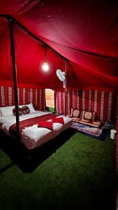 a bedroom with a bed in a red tent at Sunrise Desert Local Private Camp in Badīyah