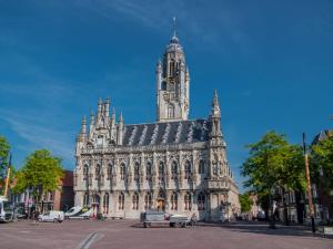 un grande edificio con una torre sopra di Slapen bij Scherp a Middelburg