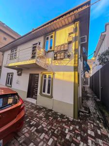 a house with a balcony and a car parked in front of it at Boss Apartment in Ikeja