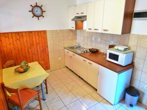 a small kitchen with a table and a microwave at Apartments Radis in Zaton